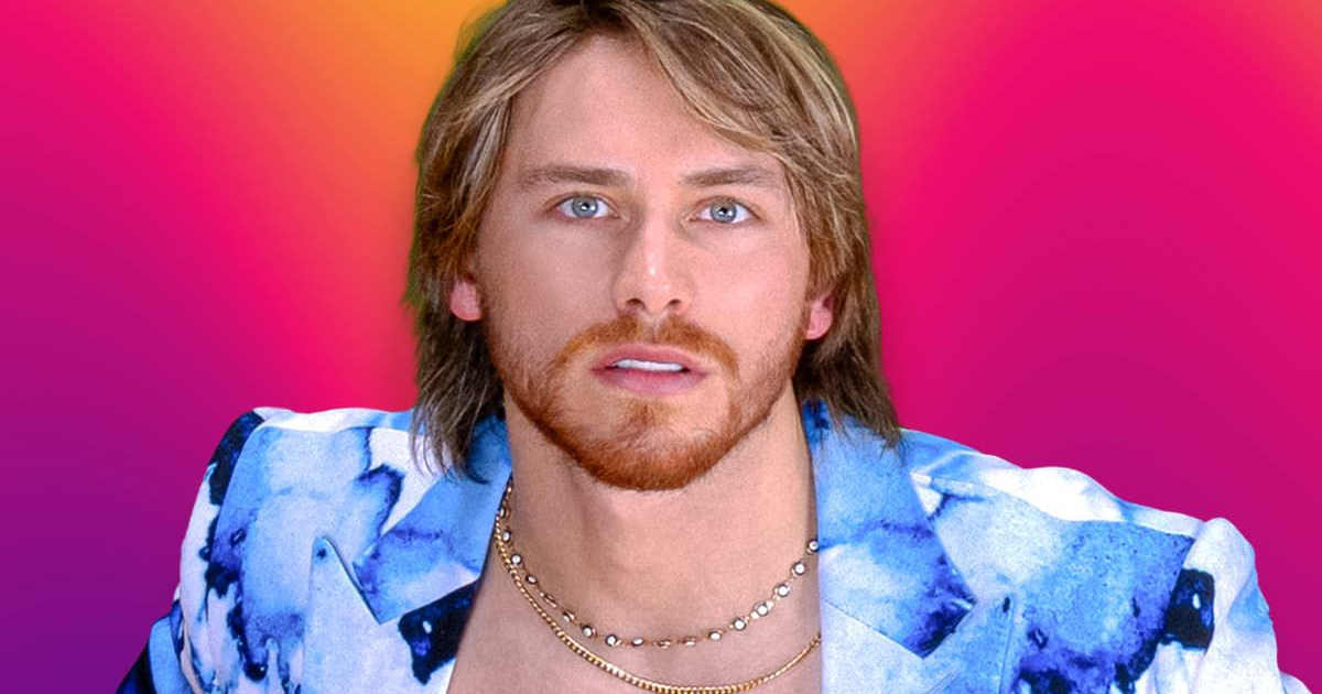 Hombre rubio con barba y chaqueta colorida frente a fondo vibrante, posiblemente Aldo Tamez de Nigris