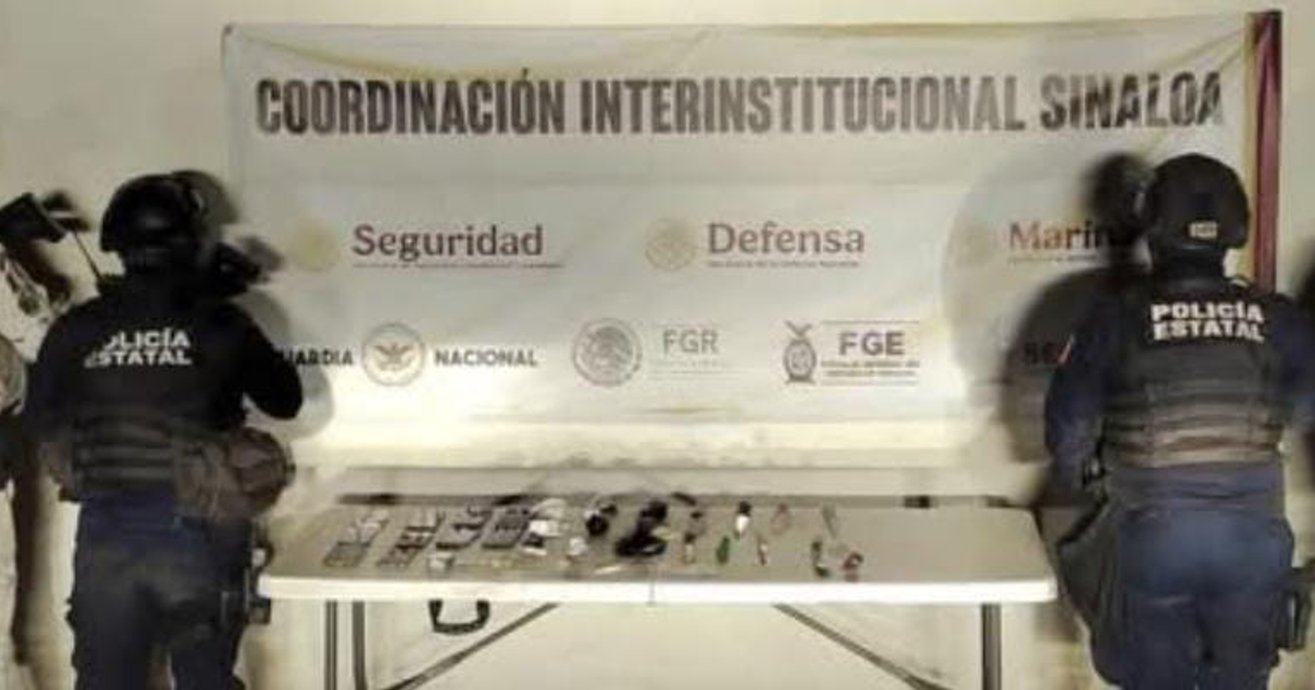 Agentes policiales de Sinaloa frente a mesa con objetos incautados, cartel de coordinación seguridad al fondo.