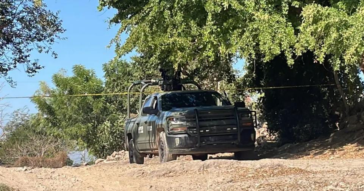 Camioneta verde con equipo de vigilancia en zona delimitada por cinta amarilla, camino de tierra y vegetación.