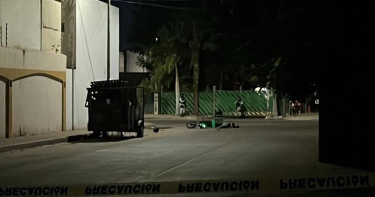 Escena del crimen nocturno en Culiacán con motocicleta caída y área acordonada