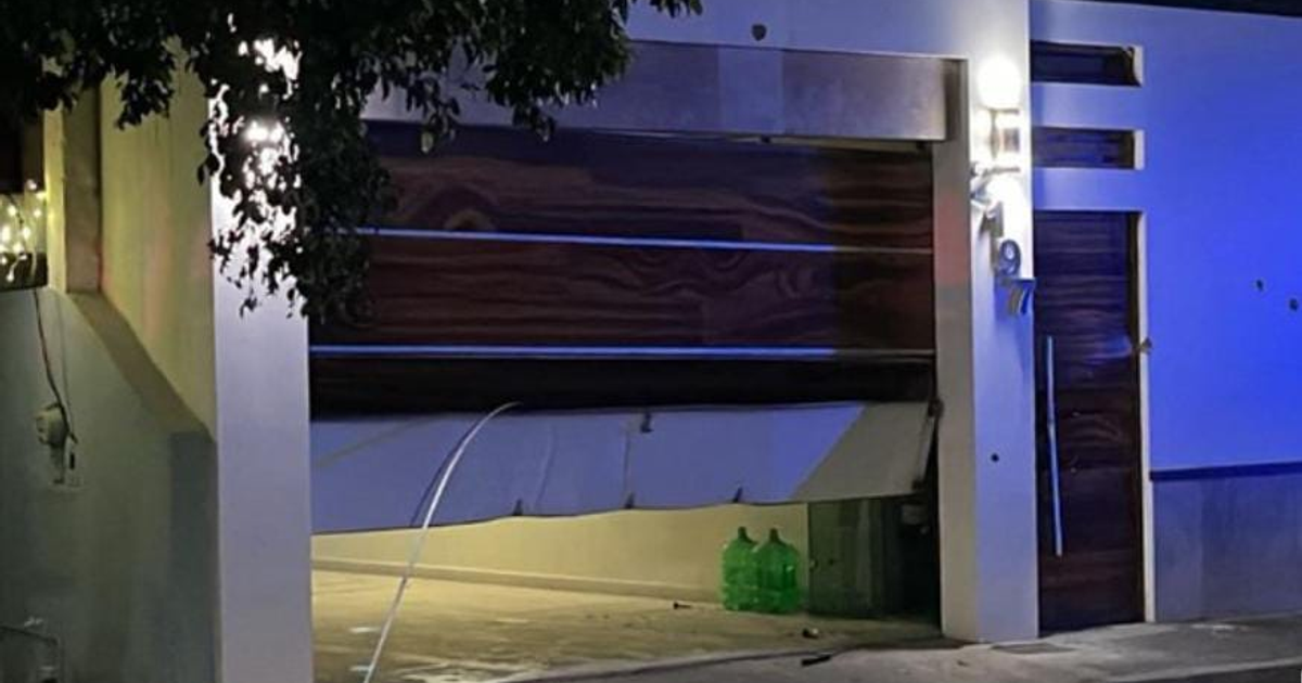 Garaje parcialmente abierto con iluminación interior en Culiacán, ambiente oscuro, ataque de El Vallado.