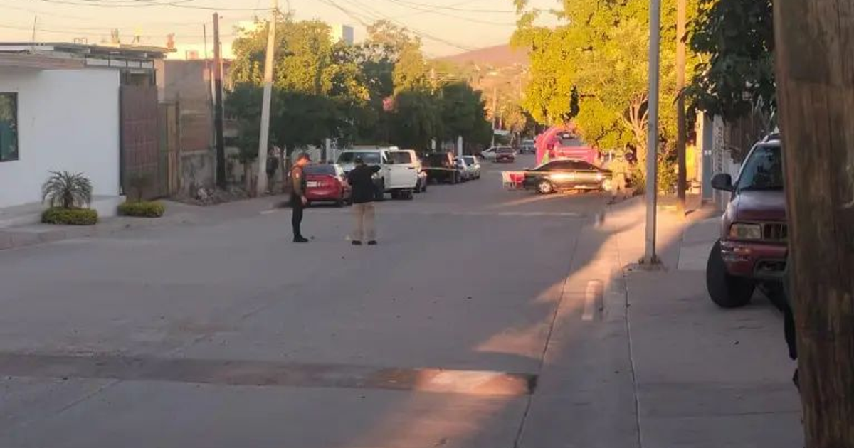 Policía y testigo observan el lugar del ataque en la calle José María Gutiérrez tras un violento incidente en Culiacán.