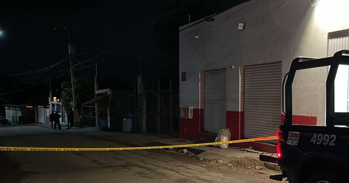 Calle oscura con vehículo policial y cinta amarilla en Culiacán, Sinaloa tras ataque armado