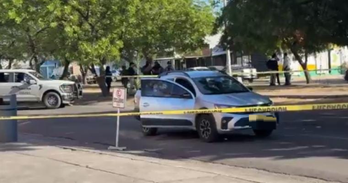 Vehículo gris con cinta amarilla de precaución en una escena policial en Culiacán.