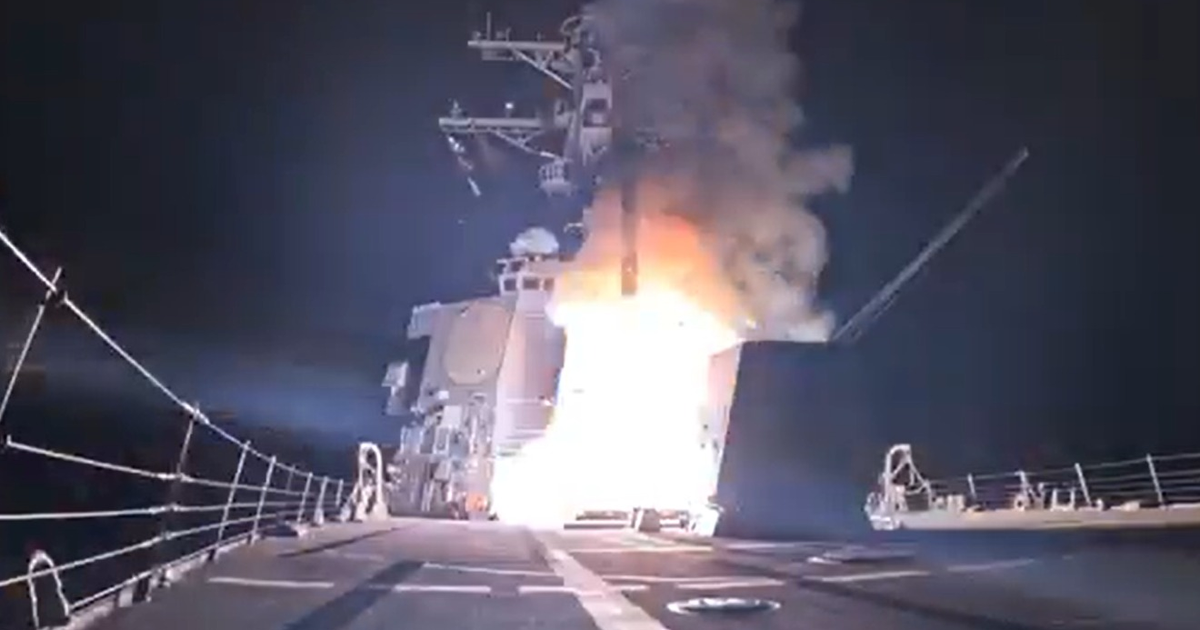 Buque militar lanza misil durante operación militar contra el Estado Islámico, con intensas llamas y humo en la oscuridad.