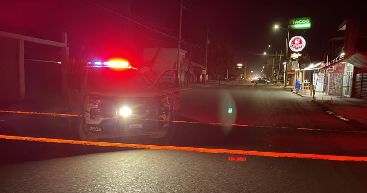 Escena de emergencia nocturna en Culiacán con vehículo policial y cinta amarilla.