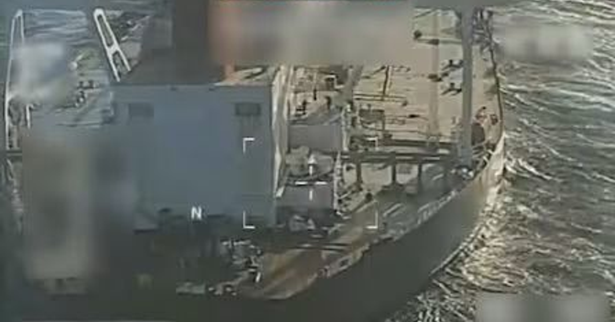 Vista aérea del buque tanque Centuries, en movimiento sobre el agua, con detalles visibles de su estructura y personas en cubierta, rodeado de ondas marinas.