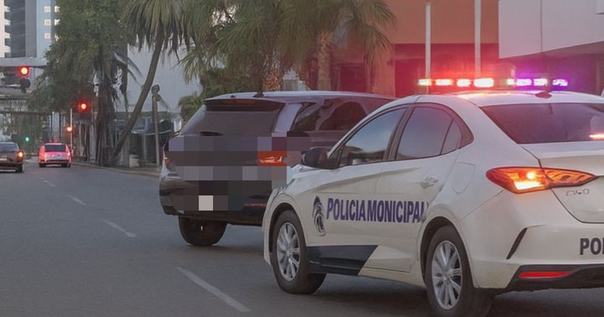 Escena de tráfico en Mazatlán con un coche de policía detenido y luces intermitentes activadas