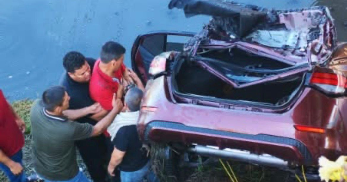 Personas rodean un vehículo volcado y sumergido tras un accidente en Navolato, Sinaloa.