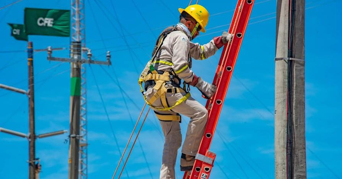 Trabajador de la CFE subiendo una escalera con equipo de seguridad