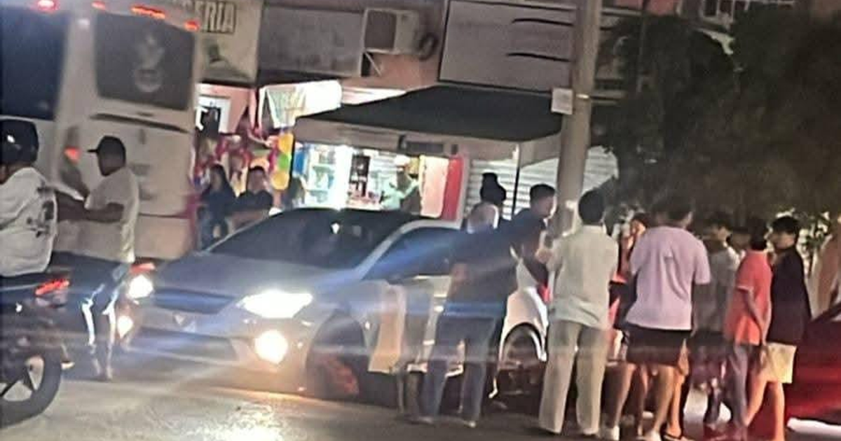 Escena nocturna de colisión en Mazatlán con grupo de personas, un automóvil claro y un camión presentes.