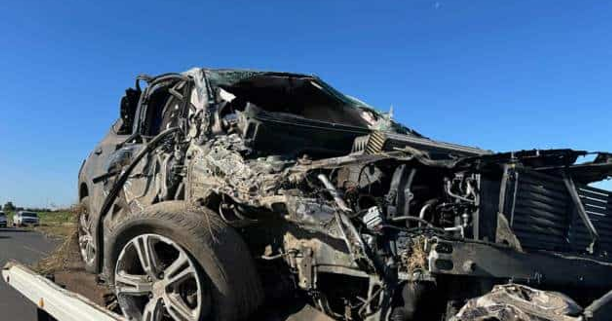 Imagen de un coche dañado tras accidente en Sinaloa, remolcado bajo cielo despejado.