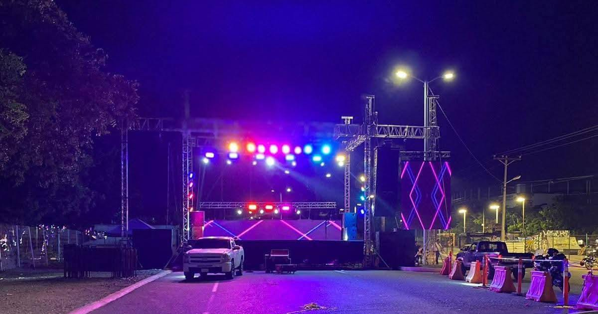 Escenario nocturno con luces de colores y amplificadores en Paseo Leonismo Internacional para show de Tatiana.