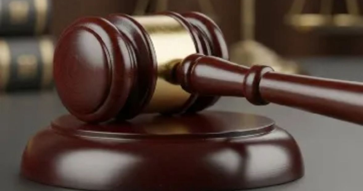 Mazo de juez junto a libros y balanza sobre fondo legal, representativo del sistema judicial.