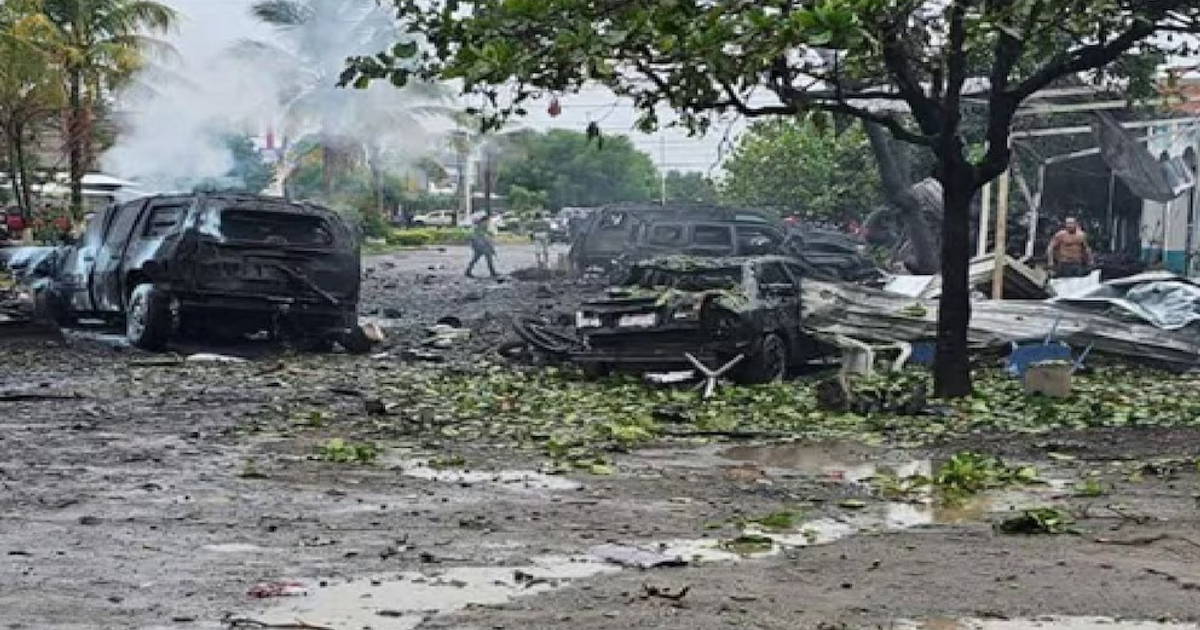 Daños y vehículos humeando en la escena del coche bomba en Coahuayana.