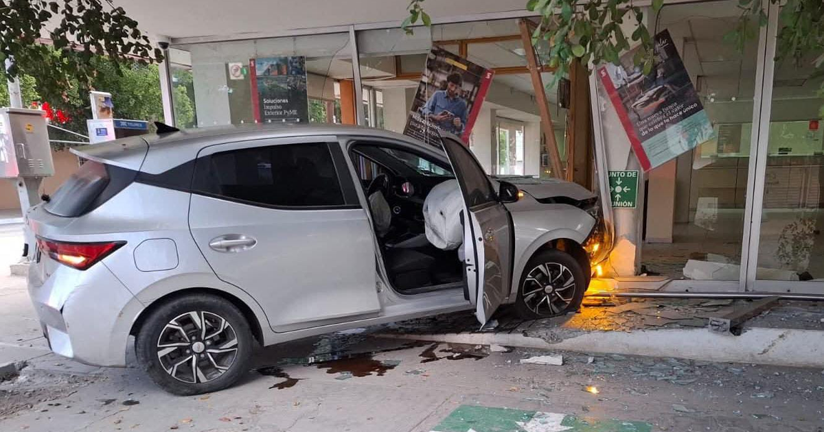 Automóvil plateado choca contra edificio en Guasave, visible airbag desplegado y daño estructural.