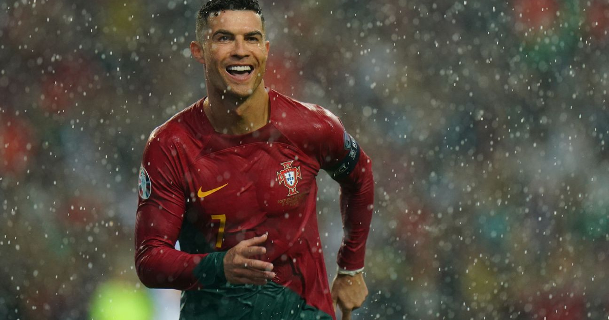 Futbolista celebrando bajo la lluvia con camiseta roja en partido México vs. Portugal en 2026.