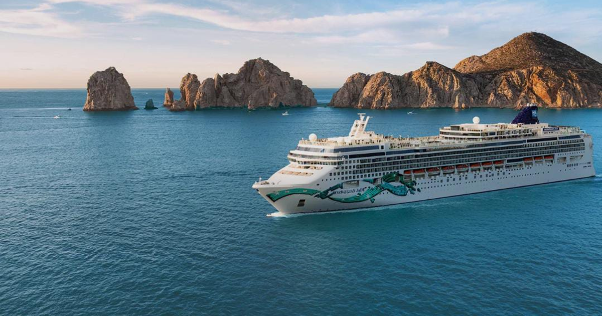 Crucero navegando cerca de formaciones rocosas en Mazatlán al atardecer