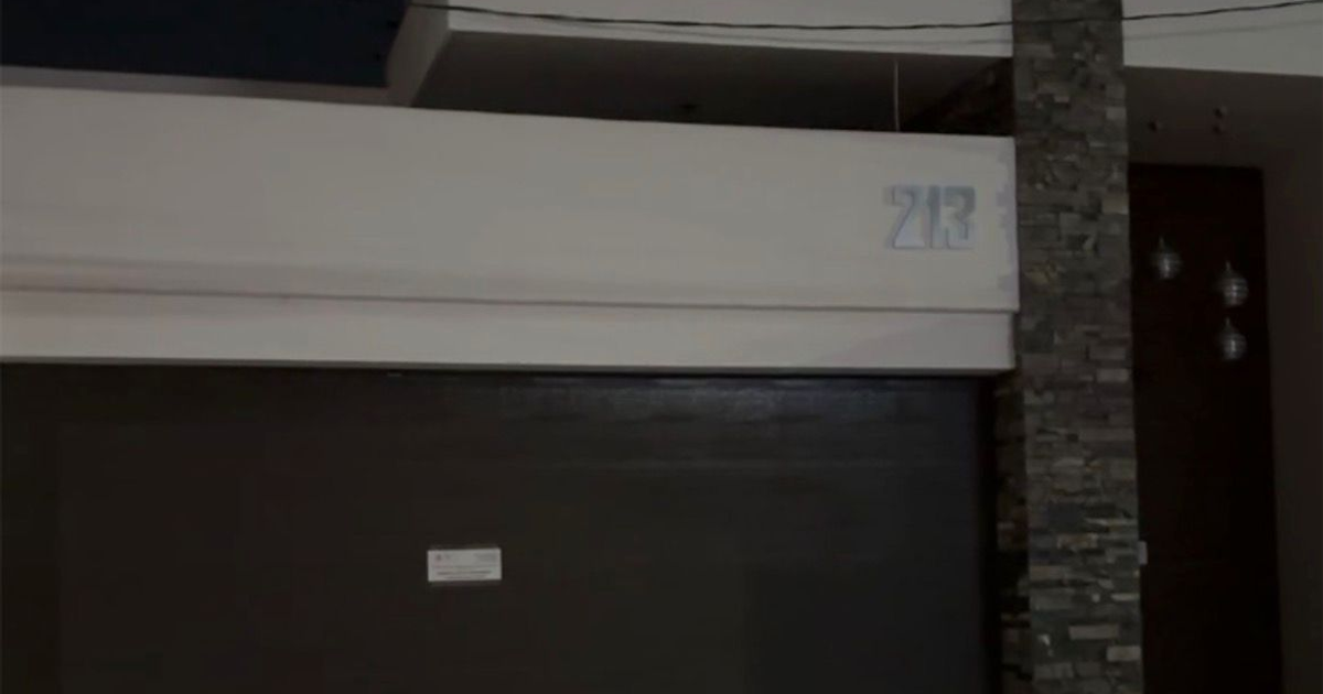 Entrada de vivienda con puerta marrón y número 213 en operativo nocturno, Culiacán