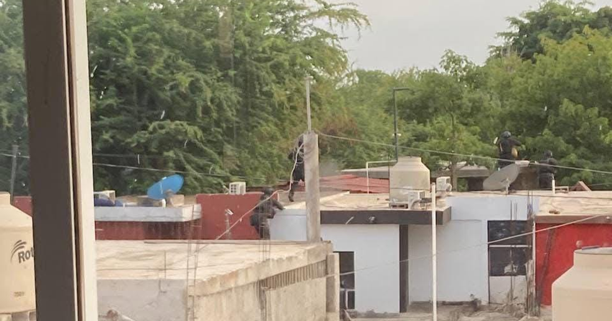 Vista aérea de techos en Navolato con personas y antena parabólica durante un operativo