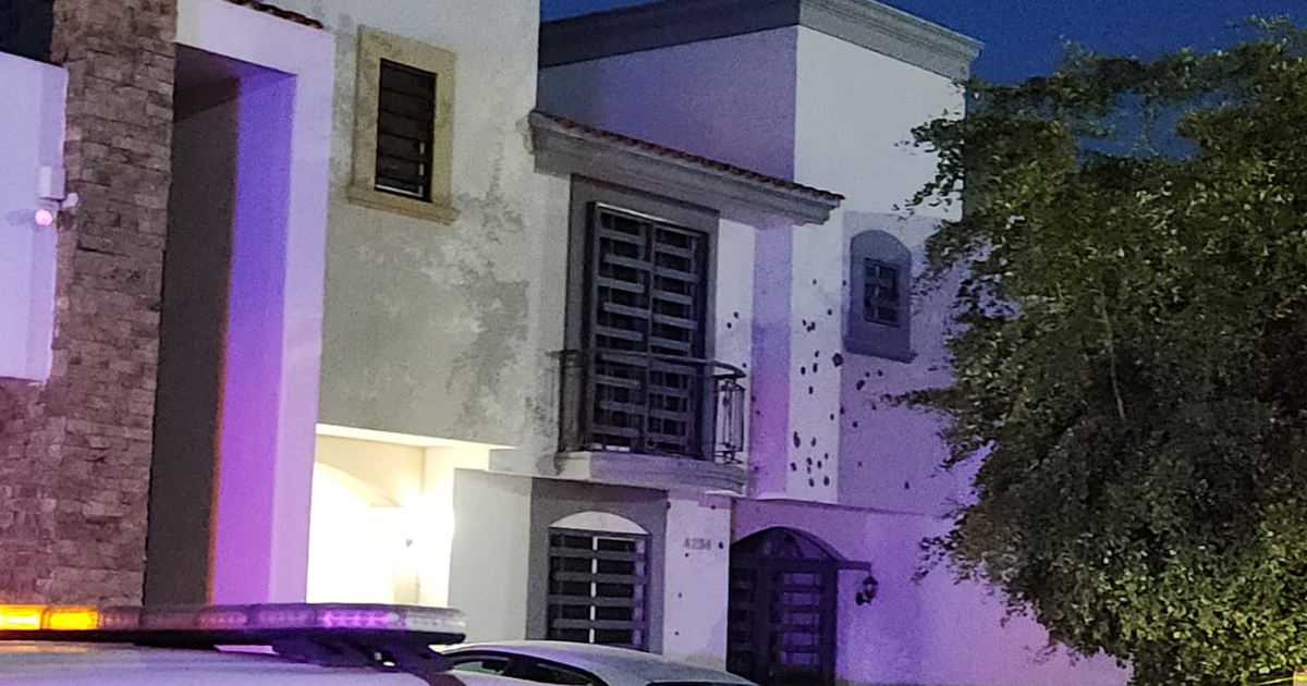 Vivienda de varios niveles afectada por impactos de bala en Culiacán, con un vehículo policial en la escena nocturna.