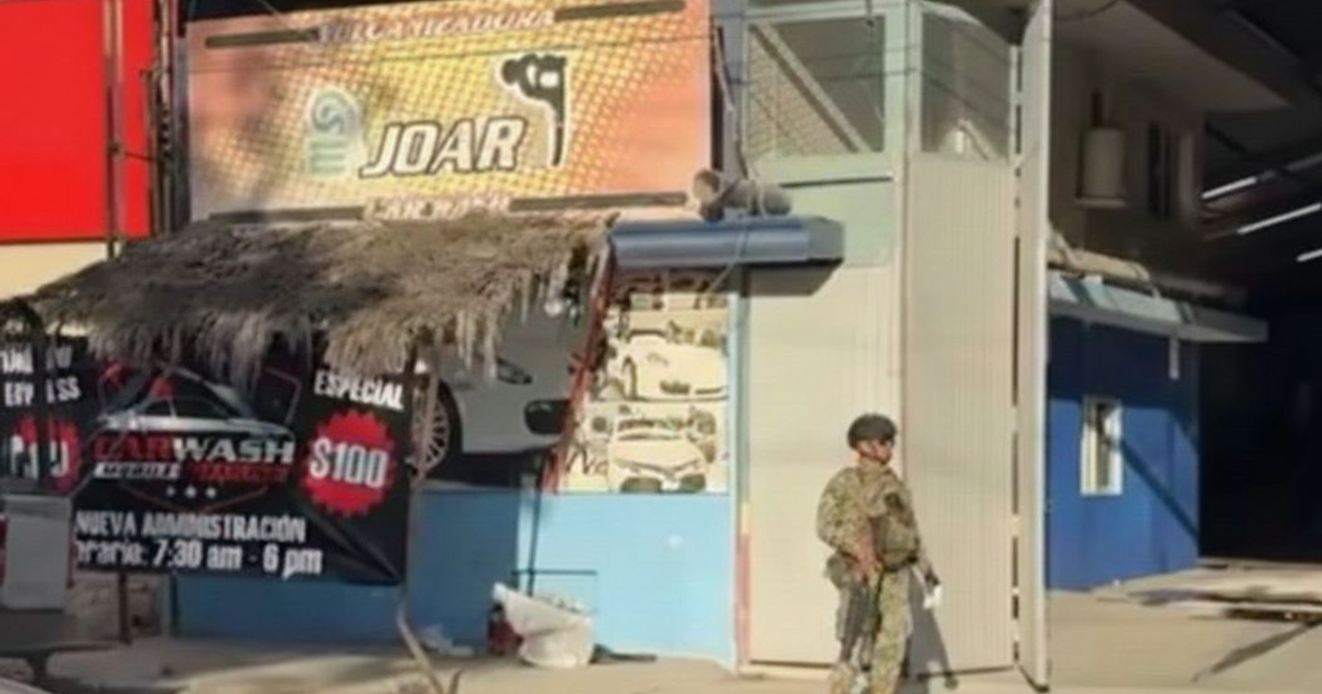 Establecimiento de autolavado "JOAR" en Culiacán con ambientación de seguridad y decoración de palma, sitio de un ataque armado sin heridos confirmados.