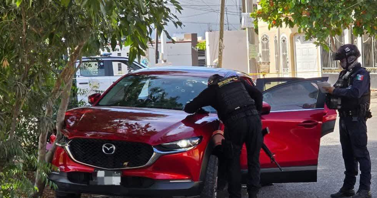 Policías revisan un coche rojo en la escena de un incidente en Culiacán.