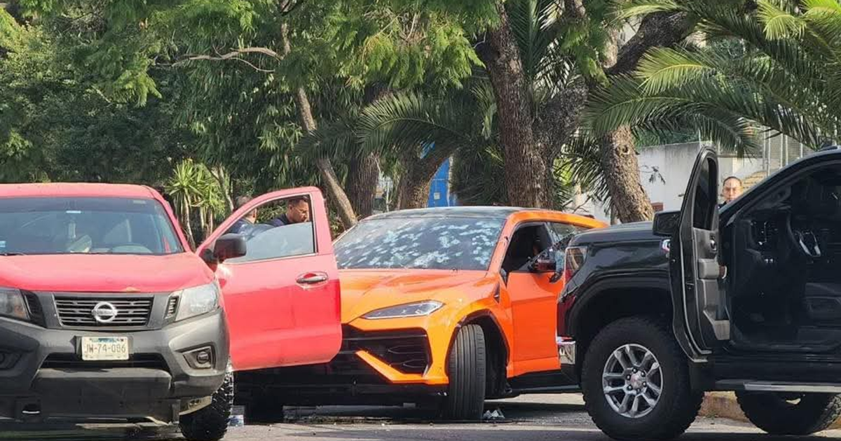 Estacionamiento con autos, incluido un SUV naranja con la puerta abierta, vinculado a un enfrentamiento en Zapopan.
