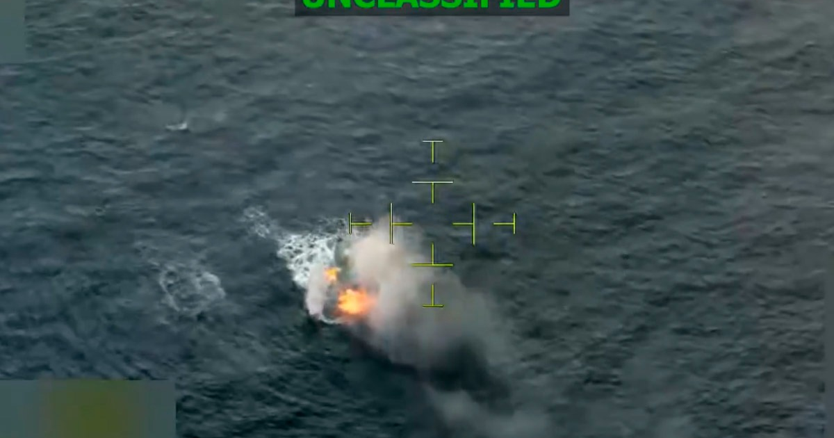 Área de agua en el mar con una explosión emergiendo, humo y llamas indican un ataque. Imagen desde un equipo de vigilancia.
