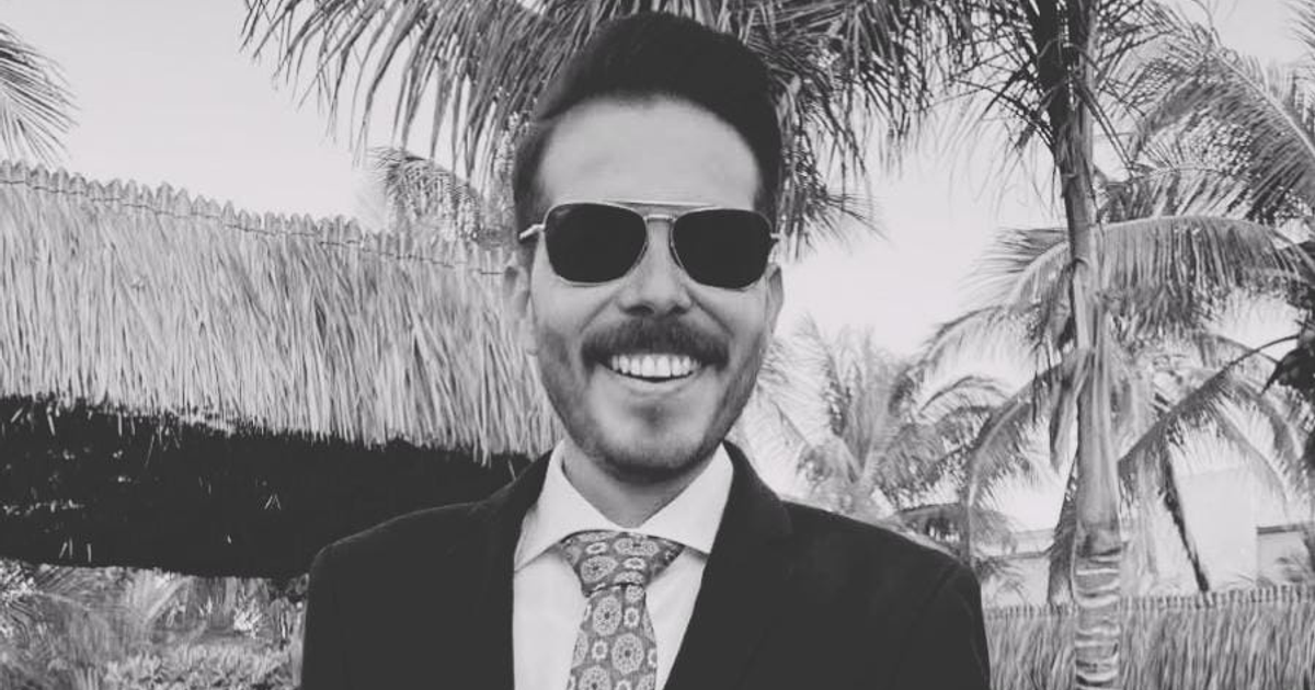 Francisco Javier Moreno Núñez sonriente con traje y gafas de sol, palmeras tropicales al fondo