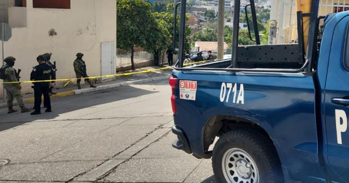 Agentes de policía y personal militar resguardan una zona acordonada en Culiacán, con edificios al fondo y un vehículo policial en primer plano.