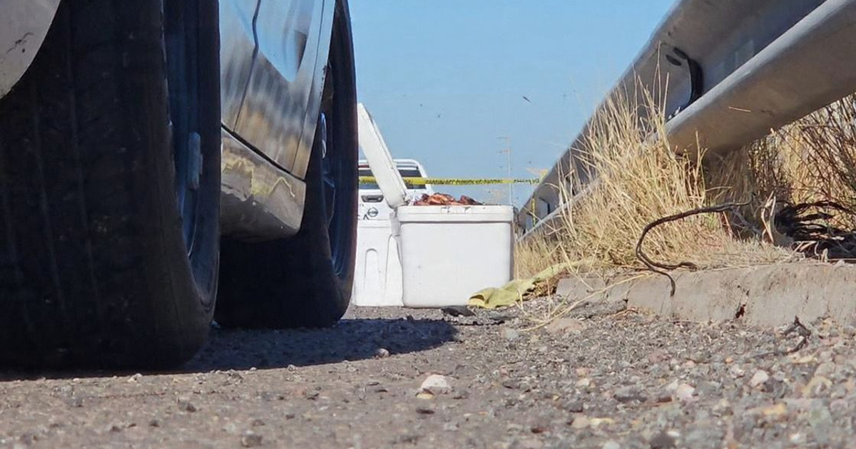 Zona rodeada con cinta de seguridad, con un camino, un vehículo y un enfriador en Culiacán.