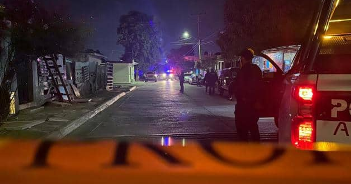 Calle nocturna en Las Malvinas con luces de autos y policía en escena de crimen