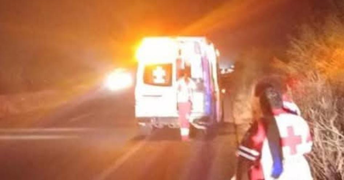 Ambulancia con luces de emergencia en carretera nocturna y rescatista acercándose, en contexto de accidente en México 15.