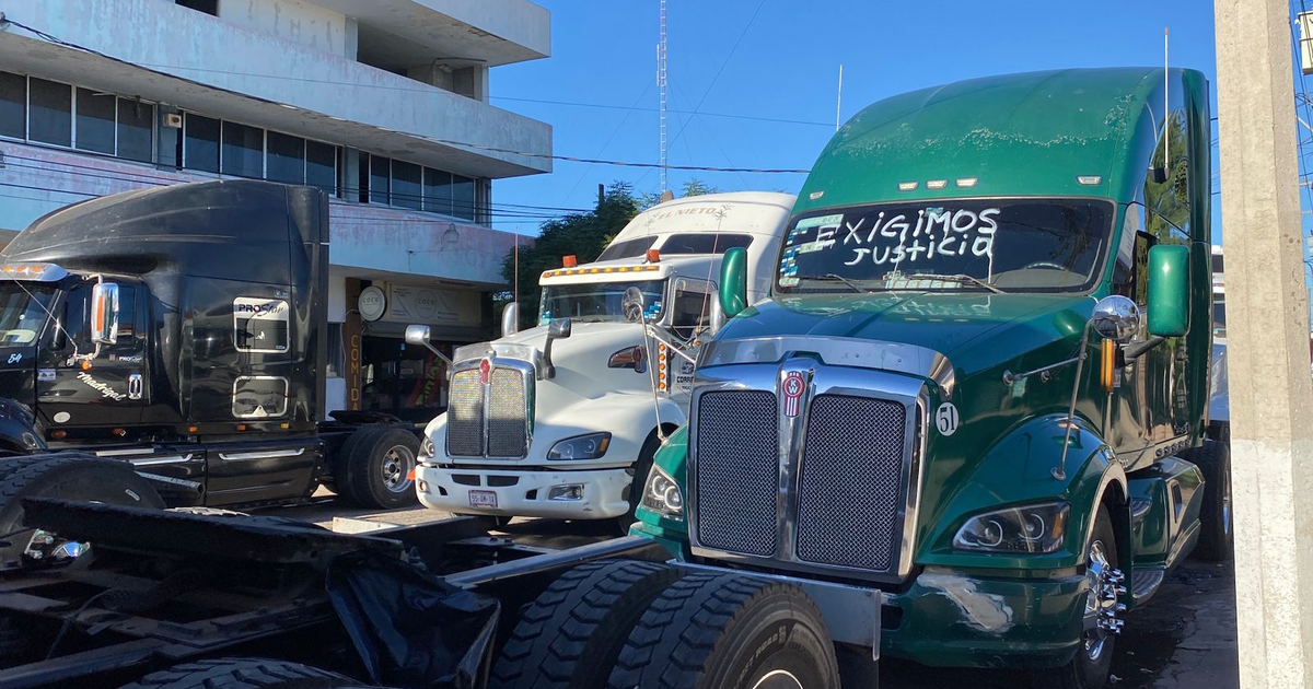 Camiones de protesta en Los Mochis frente al IMSS, destacan diversos colores y la frase 'EXIGIMOS JUSTICIA'.