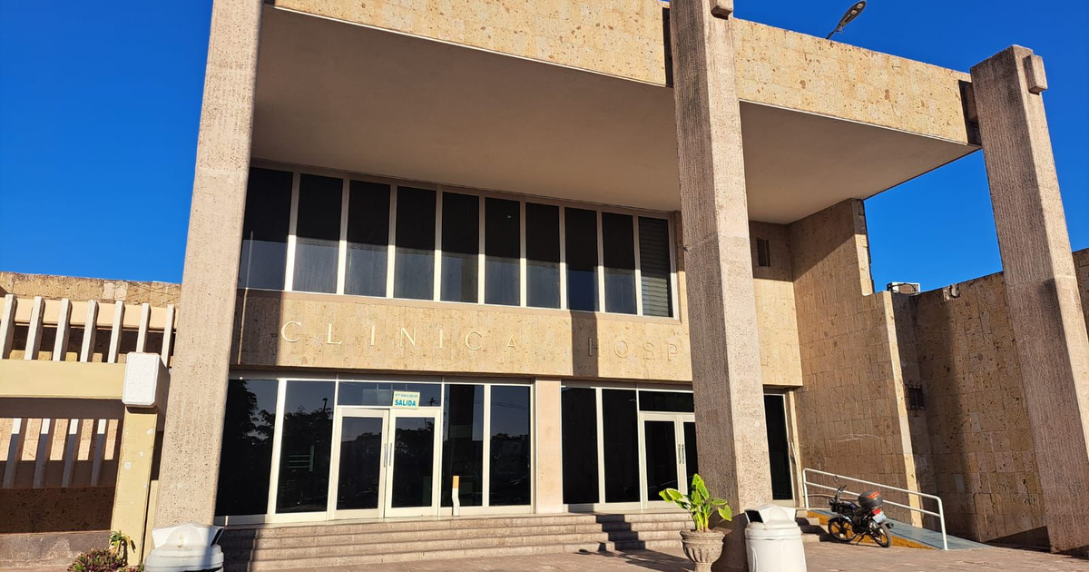 Vista del edificio 'CLÍNICA HOSP' con columnas, ventanales grandes y una planta en el frente, señalado por su diseño contemporáneo.