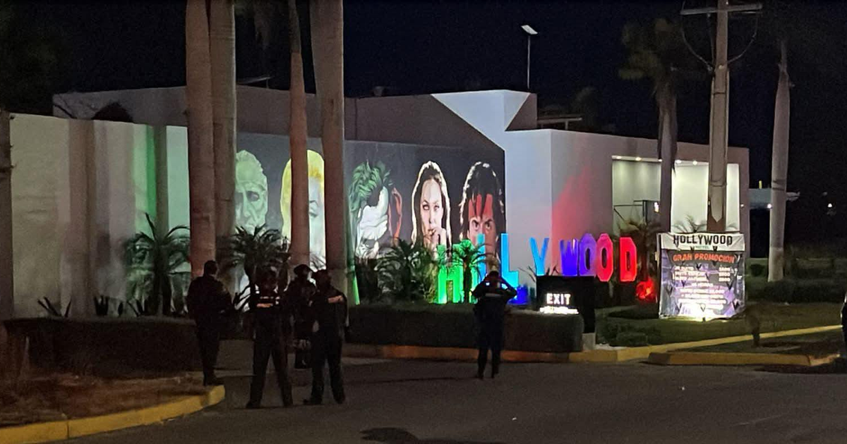 Edificio iluminado en la noche con proyecciones faciales y presencia policial durante evento en Culiacán