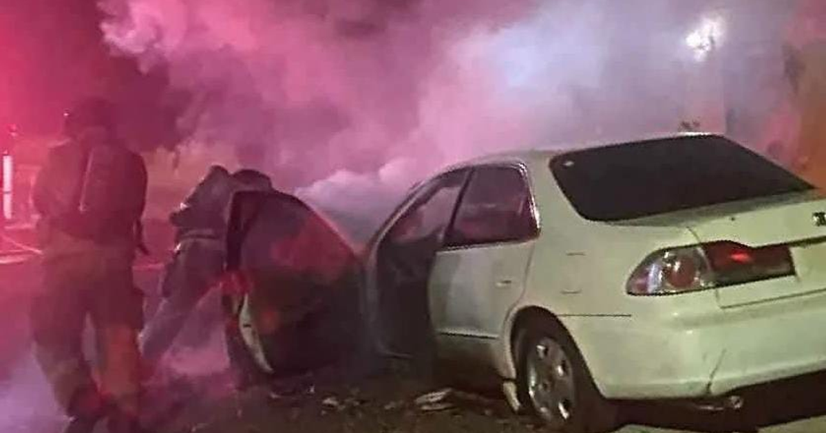 Intervención de bomberos extinguiendo incendio en automóvil blanco en colonia Benito Juárez, Mazatlán.