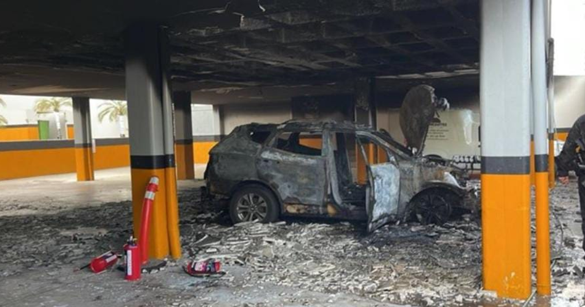 Auto calcinado en estacionamiento con escombros y extintor cercano en Hotel Tres Ríos, Culiacán
