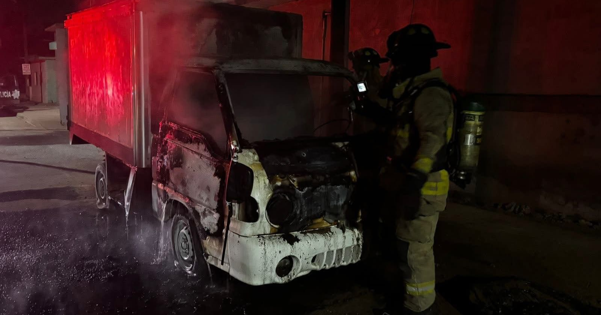 Camioneta chamuscada en Mazatlán con bomberos trabajando para apagar el incendio