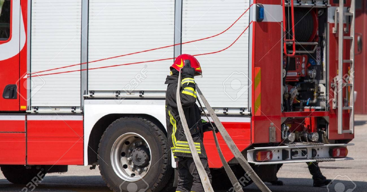 Bombero con manguera y camión rojo durante emergencia en Guasave