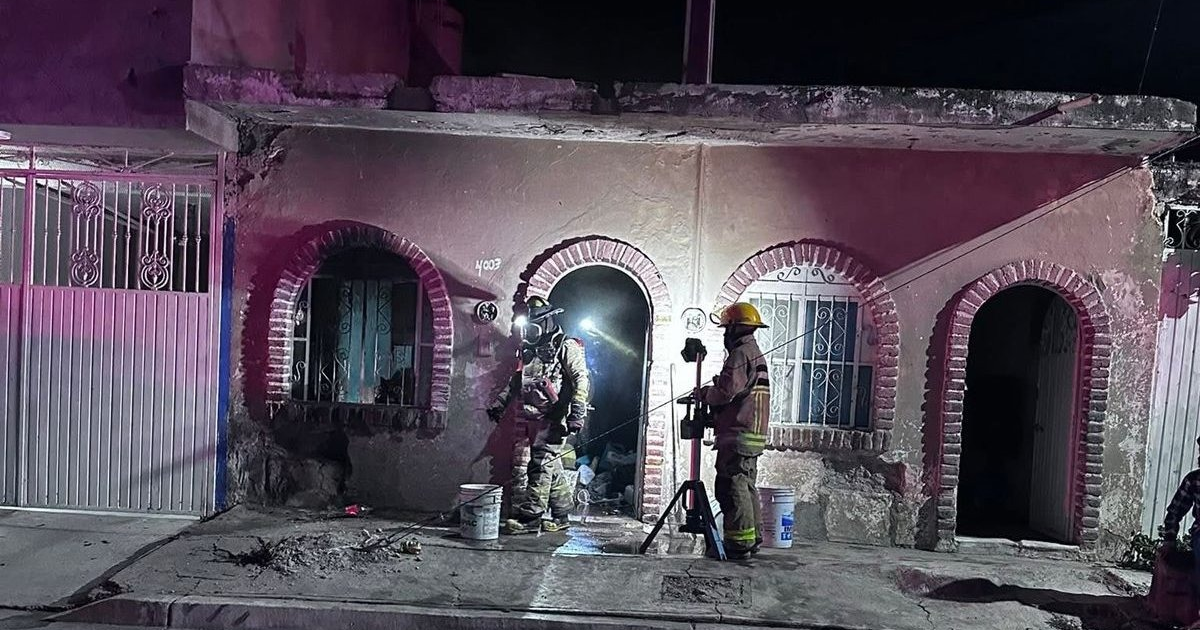 Bomberos trabajando durante la noche en un incendio en Mazatlán, con luces rosadas del entorno.