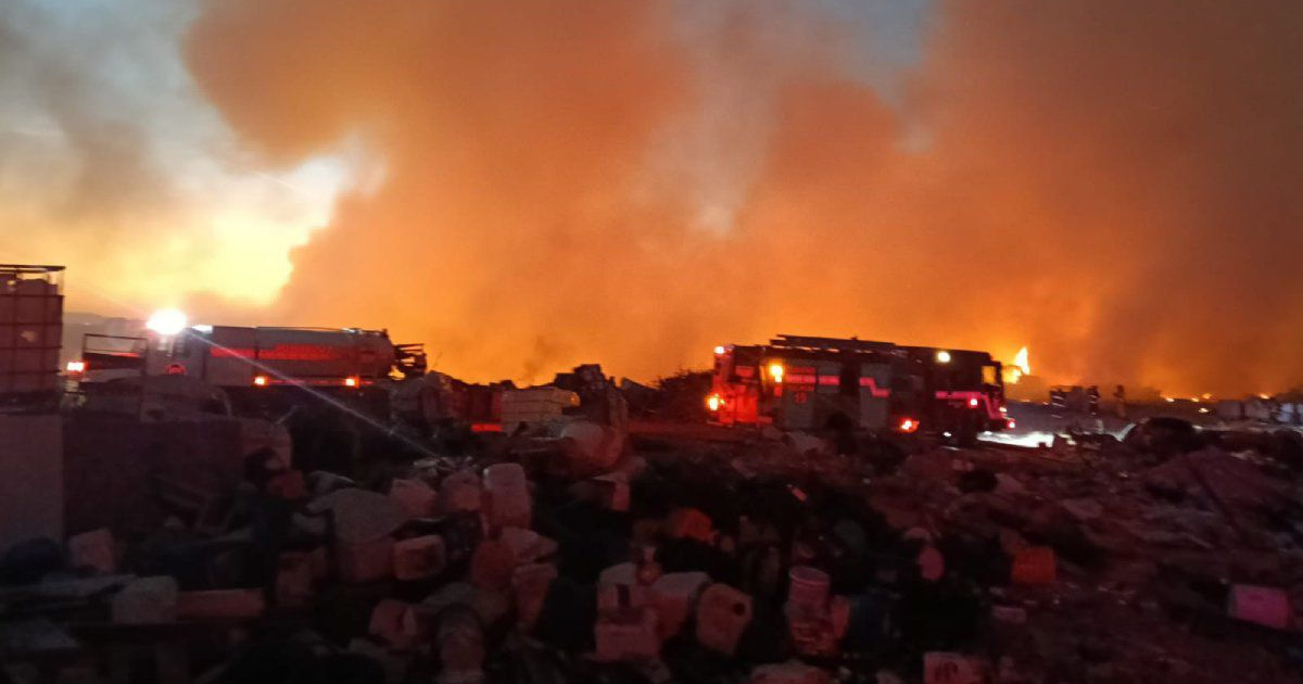 Incendio en basurón clandestino en Culiacán, con humo y camiones de bomberos en acción.