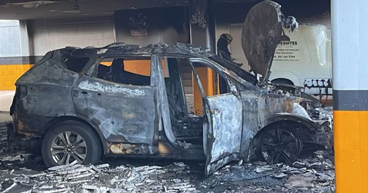 Imagen de un vehículo Hyundai SUV incendiado en estación de hotel Home Suites, Culiacán. Bombero presente.