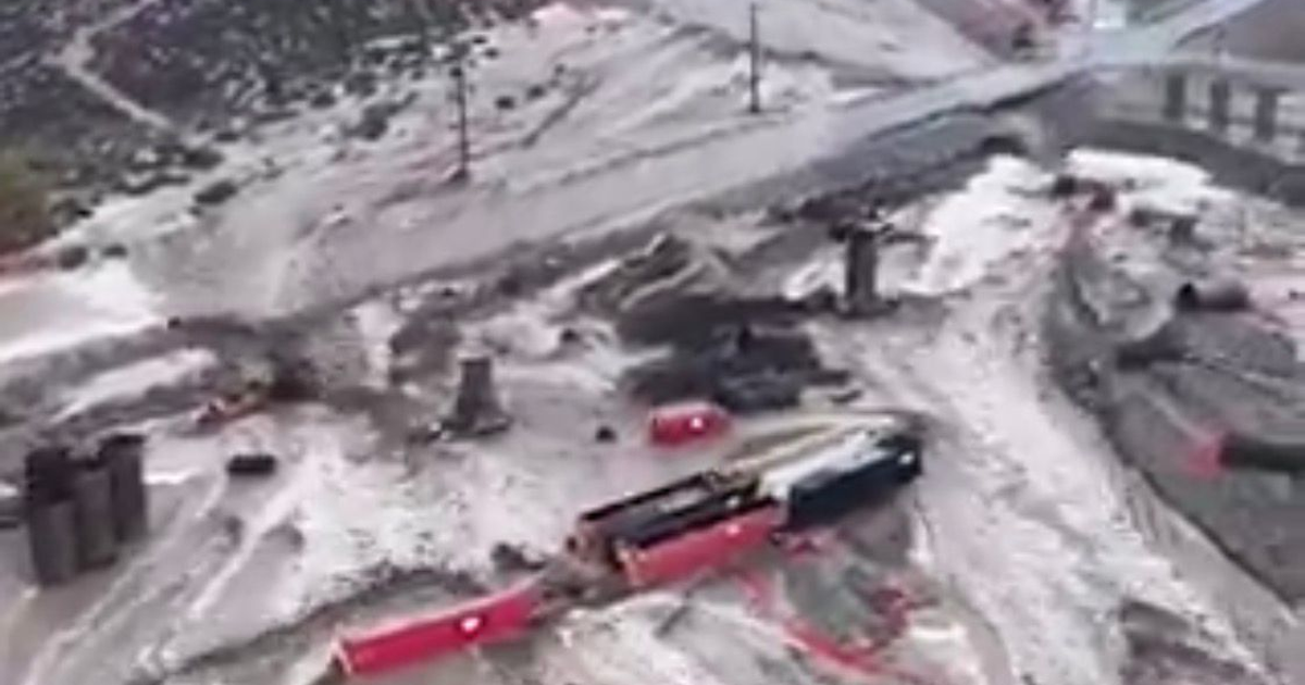 Inundación en el sur de California con agua y lodo bloqueando carreteras y rodeando vehículos y estructuras.