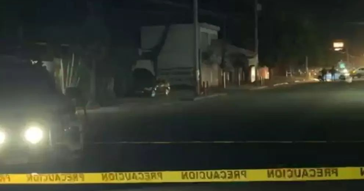 Escena nocturna de incidente en Culiacán, vehículo con luces y cinta de precaución