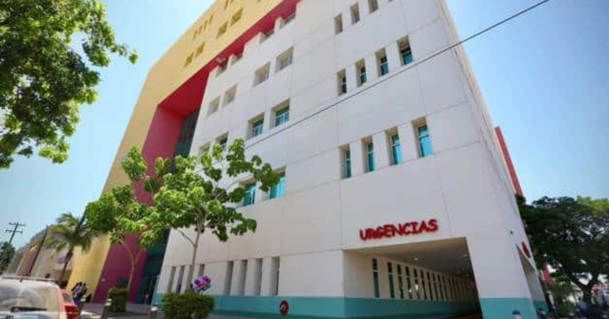 Vista de un moderno edificio de salud con el letrero 'URGencias' en un día soleado.