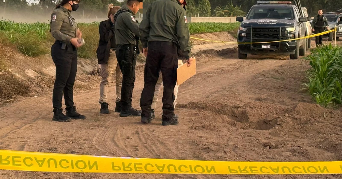 Escena forense en Navolato, Sinaloa con peritos investigando un hallazgo en camino de terracería.