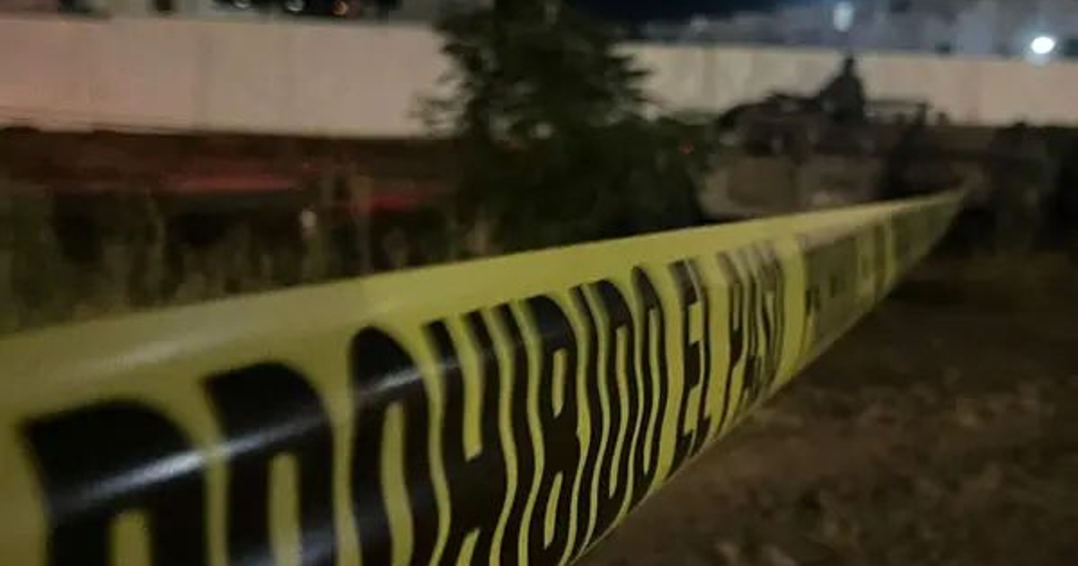 Cinta amarilla de seguridad con 'PROHIBIDO EL PASO' en escena nocturna en Culiacán.