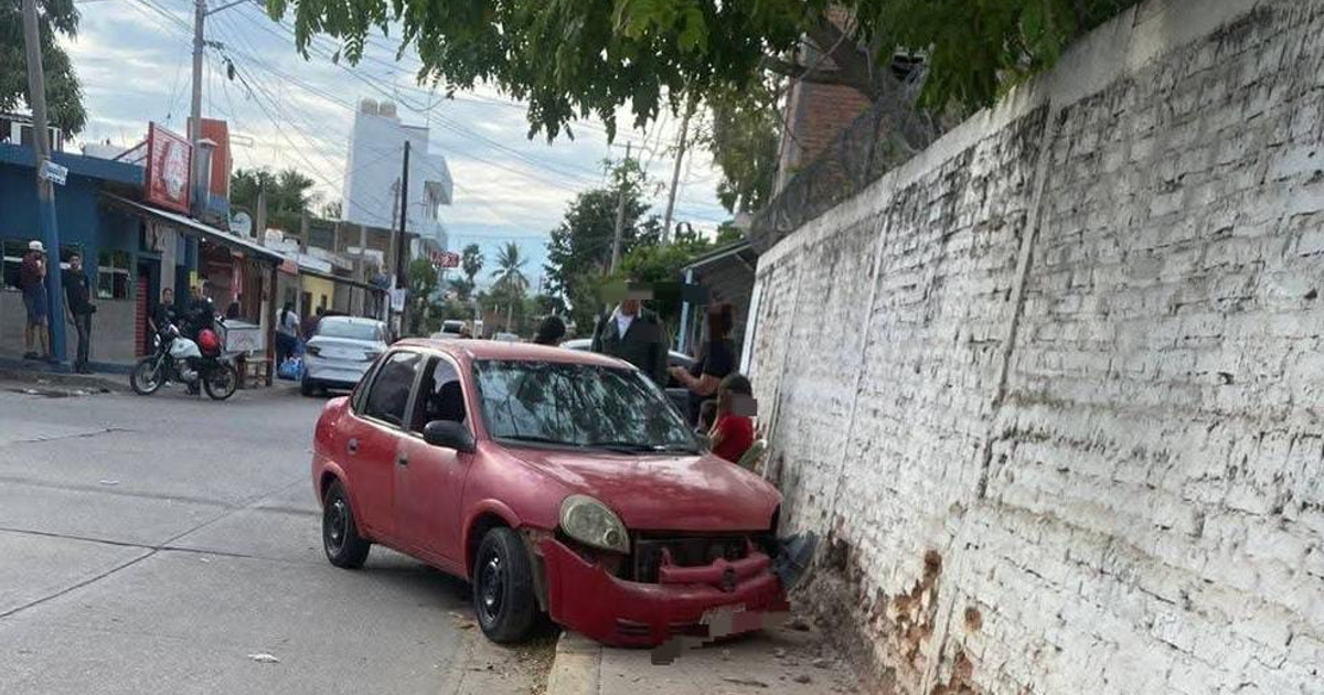 Auto rojo dañado tras choque en Mazatlán, foto captada en escena urbana concurrida.